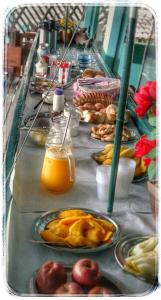 a buffet line with plates of food and orange juice at Pousada Gabriel in Praia de Araçatiba