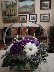 ein Strauß mit lila und weißen Blumen auf dem Tisch in der Unterkunft Classic Style Apartment in Belgrad
