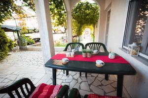 a table on a patio with a red table cloth at Ivano Apartments in Grebaštica