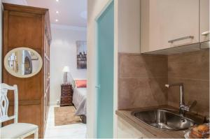 eine Küche mit einem Waschbecken und ein Zimmer mit einem Bett in der Unterkunft Apartamento en Casco Antiguo in Logroño