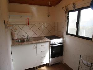 a small kitchen with a sink and a stove at Casa Helena in Aljezur
