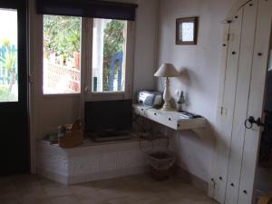 a living room with a tv and a window at Casa Helena in Aljezur