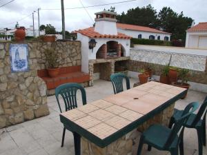 a patio with a table and chairs and a pizza oven at Casa Helena in Aljezur