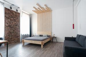 um quarto com uma cama, um sofá e uma parede de tijolos em Artisan Home em Bérgamo