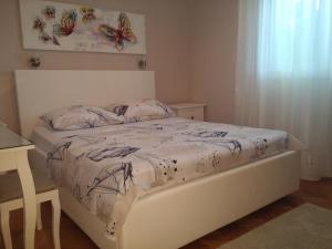 ein Schlafzimmer mit einem weißen Bett mit Schmetterlingen darauf in der Unterkunft Tone & Marta Apartments in Rogoznica