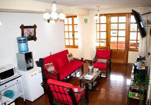 a living room with red chairs and a red couch at The House in Tacna
