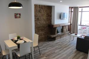 a living room with a dining table and a fireplace at Nogalera Beach Apartment in Torremolinos