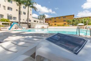 a sign on a bench in front of a swimming pool at Iguassu Flats Hotel in Foz do Igua&ccedil;u