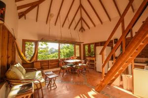 a living room with a table and chairs and a large window at Clave Verde Ecolodge in Las Terrenas