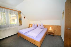 Un dormitorio con una cama con almohadas moradas y una ventana en Kniebergerhof, en Liebenfels