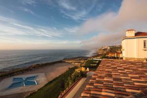 an aerial view of a building and the ocean at Chalet O Amorzinho Sintra Praia in Sintra
