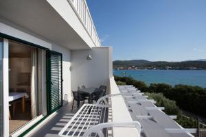 een balkon met witte stoelen en uitzicht op het water bij Villa Marijola in Lovište
