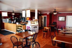 a restaurant with tables and chairs and a bar at Sauerdough Lodging in Seward