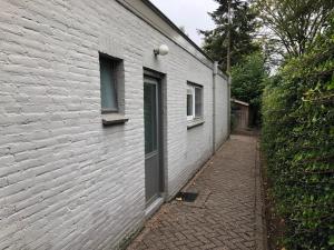 a white building with a door and a brick alley at Appartement BBwB in Breda
