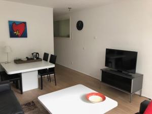 - un salon avec une table et une télévision dans l'établissement Appartement BBwB, à Breda