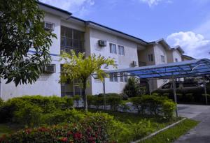 a white building with a blue canopy in a yard at Dumeros in Abuja