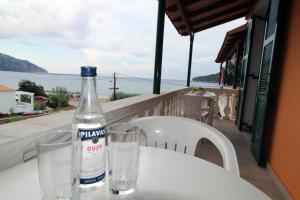 eine Flasche und zwei Gläser auf dem Tisch sitzen in der Unterkunft House Dimitri Agios Georgios Pagoi Corfu in Agios Georgios Pagon