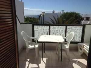 コスタ・デル・シレンチオにあるCalle Hesperidesの白いテーブルと椅子付きのバルコニー