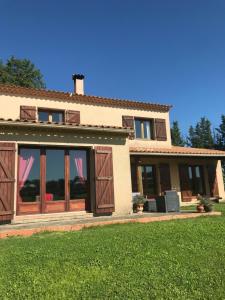 a house with sliding glass doors and a yard at Domaine de Peilhan in Roujan