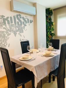 a dining room table with a white tablecloth and wine glasses at Apartamento Malagueta in Málaga