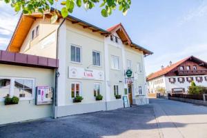 a large white building on the side of a street at Taverna Unik in Saaldorf