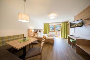 ein Hotelzimmer mit einem Bett und einem Esstisch in der Unterkunft Apart Talblick in Sölden