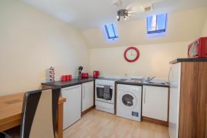 a kitchen with a washing machine and a washer and dryer at 7 Varis Apartments in Forres