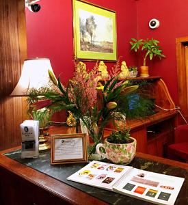 a wooden table topped with a vase filled with flowers at Eureka Inn, Trademark Collection by Wyndham in Eureka