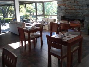 un restaurante con mesas y sillas y una chimenea en Posada Piedras Del Sol en Villa General Belgrano