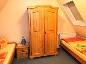 einen Holzschrank in einem Schlafzimmer mit 2 Betten in der Unterkunft FH Schmidt in Hohnstein