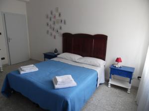 una camera da letto con un letto blu con due asciugamani di B&B Via Vinci a Potenza