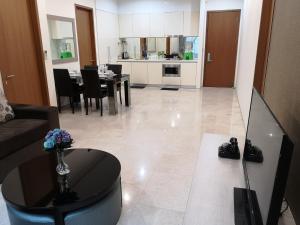 a living room with a table and a kitchen at Soho Suites Klcc By Pnut in Kuala Lumpur