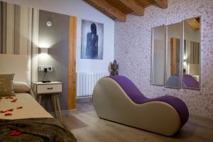 Un dormitorio con una silla morada y blanca en una habitación en Tantra Love, en Lancharejo