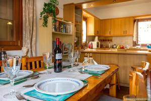 a kitchen with a table with a bottle of wine at Perla di Mare in Symi