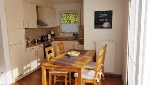 a kitchen with a wooden table and chairs in a kitchen at Pier 605 - 4 Sterne inklusive POWER WLAN - 2 Parkplätze - Wäschepaket #Bestpreisgarantie# in Zingst