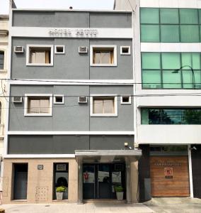 a tall gray building with windows and doors at Hotel Petit in Córdoba