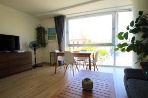 a living room with a table and chairs and a large window at Au cœur de Strasbourg, 3 pièces vue sur l'Ill! in Strasbourg