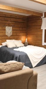 a bedroom with a large bed with wooden walls at Villa Orohat 2 in Rovaniemi