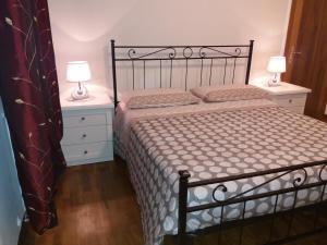een slaapkamer met een bed met 2 nachtkastjes en 2 lampen bij Casa Vacanze "Ai piedi di Assisi" in Bastia Umbra