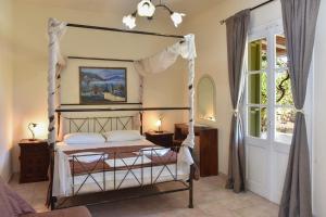 a bedroom with a canopy bed and a window at Giannakas Studios in Platis Yialos Sifnos