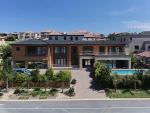 a large house with a pool in front of it at Alimama Spaces: Manson Mansion in Randjesfontein