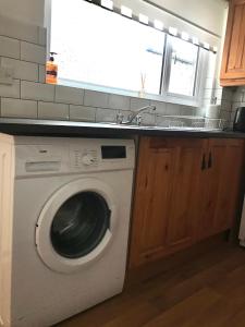 een wasmachine in een keuken met een wastafel bij Castleton townhouse in Belfast