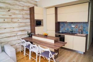 cocina con mesa de madera y sillas blancas en Sofia Central Luxury Apartment en Sofía