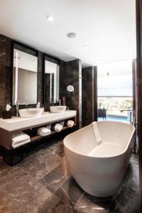 
a bath room with a tub and a sink at Radisson Blu Hotel, Larnaca in Larnaca
