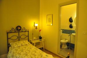 a bedroom with a bed and a bathroom with a toilet at Il Moscondoro di MZ in Bologna