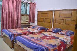 two beds sitting next to each other in a bedroom at Hyperion Sea View in Cox's Bazar