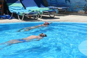 two people are swimming in a swimming pool at Samson΄s Village in Perissa