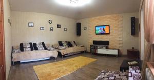 a living room with two couches and a tv at Дом в центре in Pyatigorsk