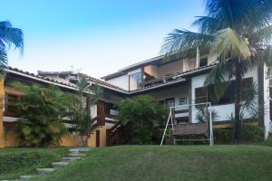 a building with palm trees in front of it at Aloha Buzios in Búzios