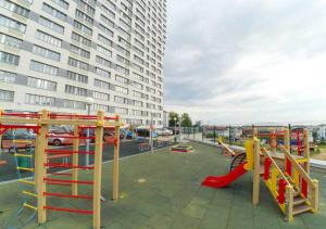 un parque infantil con tobogán y equipo de juegos en un edificio en Апартаменты Bliss в центре Казани en Kazán